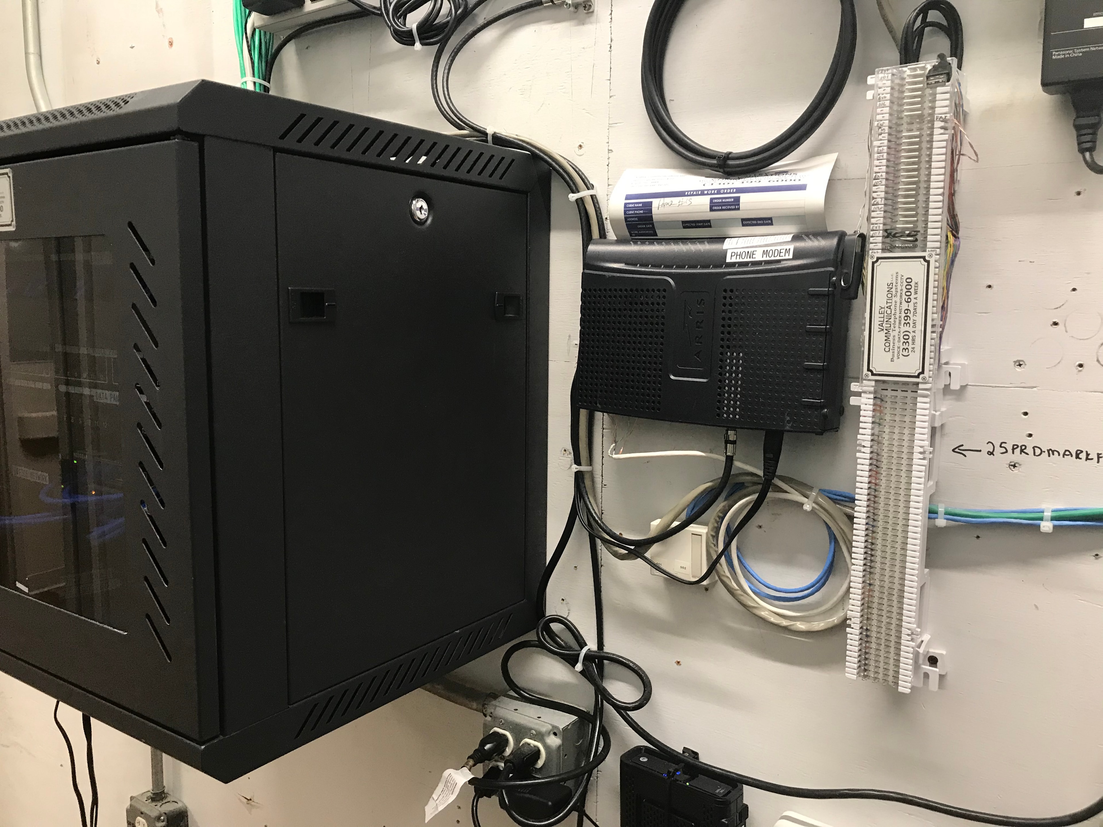 Wall-mounted network enclosure with phone modem and structured cabling
