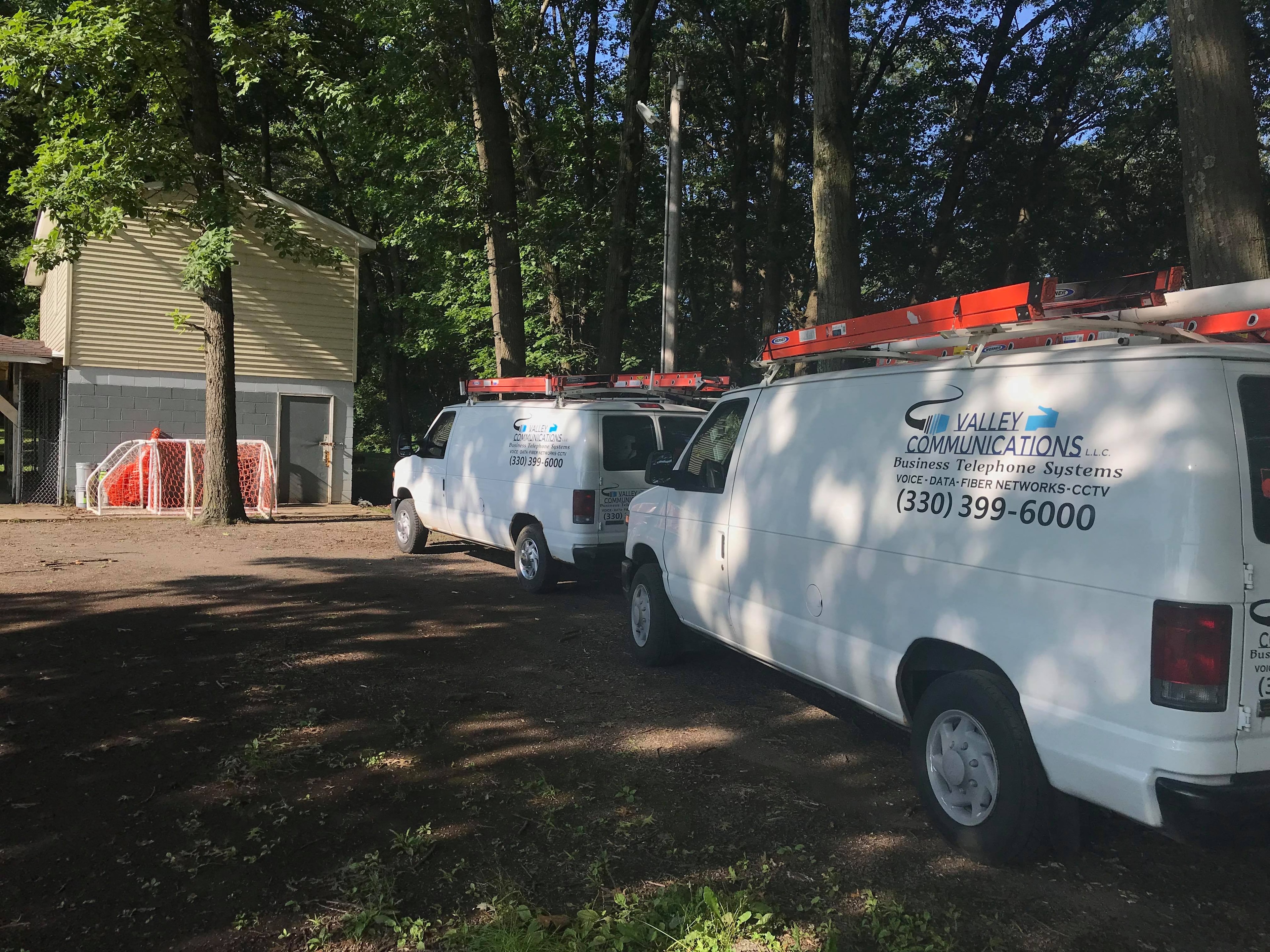 Valley Communications LLC service vans at a job site