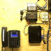 VoIP phone and networking equipment on work bench